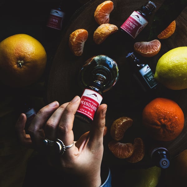 Бутылка эфирного масла мандарина наливается в сосуд